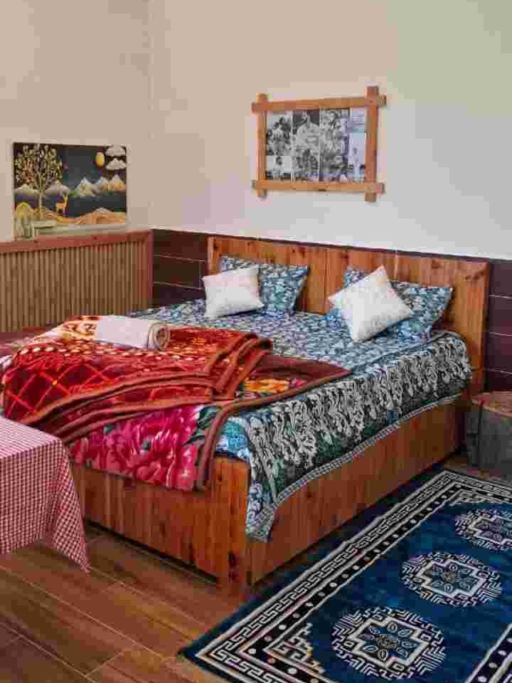 King-size bed and traditional wooden furnishings in a deluxe room at Hotel Snow View