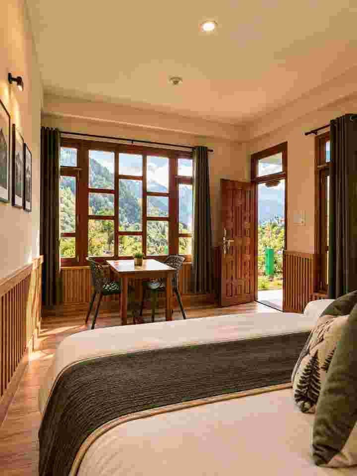 Hotel room with large wooden windows overlooking the Himalayan surroundings near Tosh